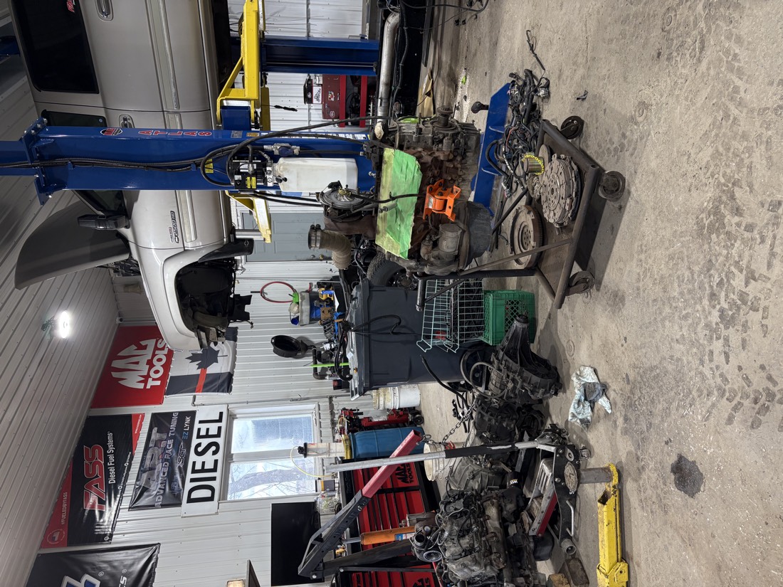 Moteur sorti du véhicule, posé au sol de l’atelier.